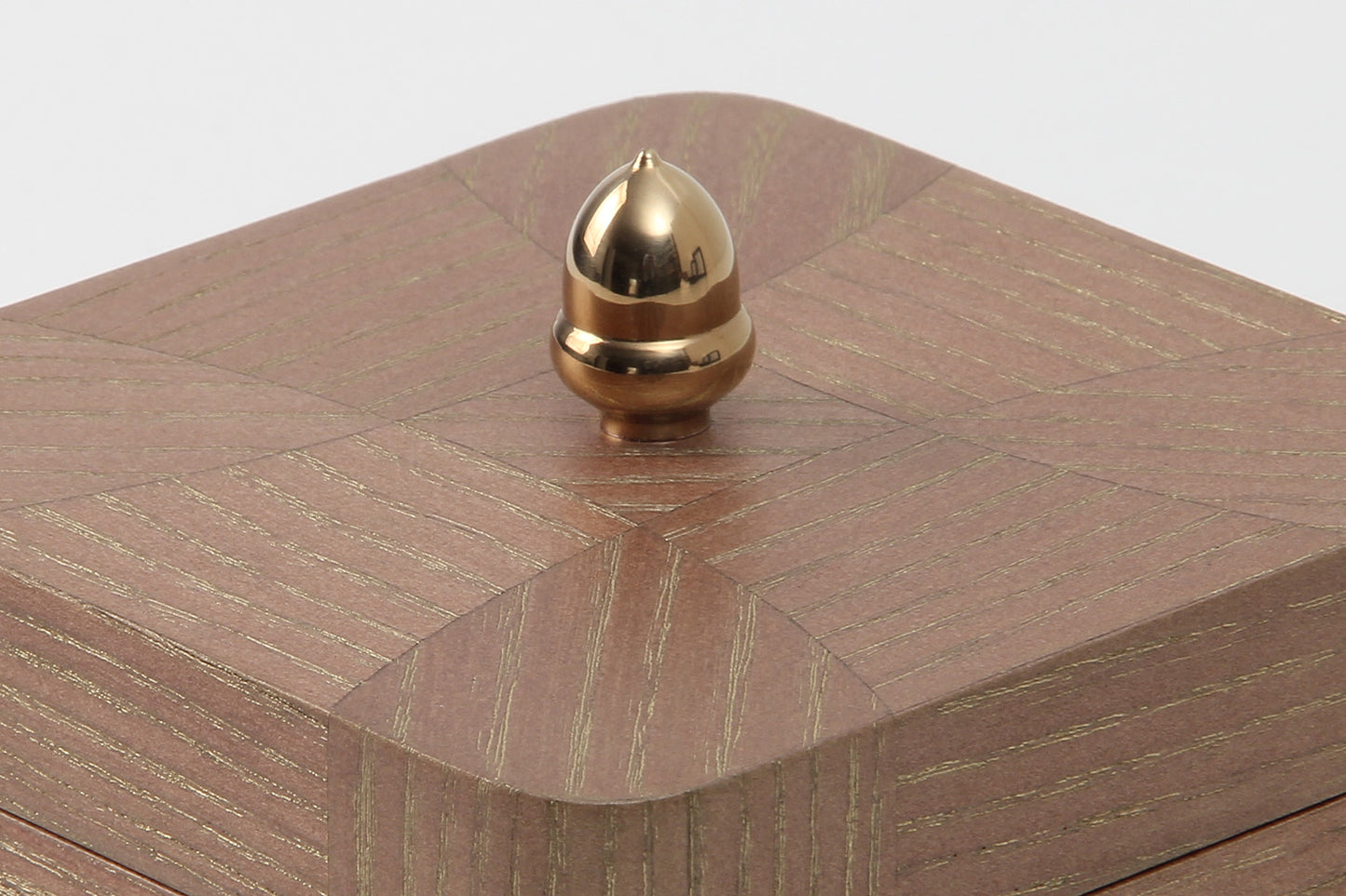 Close-up of gold grain texture on oak jewelry box
