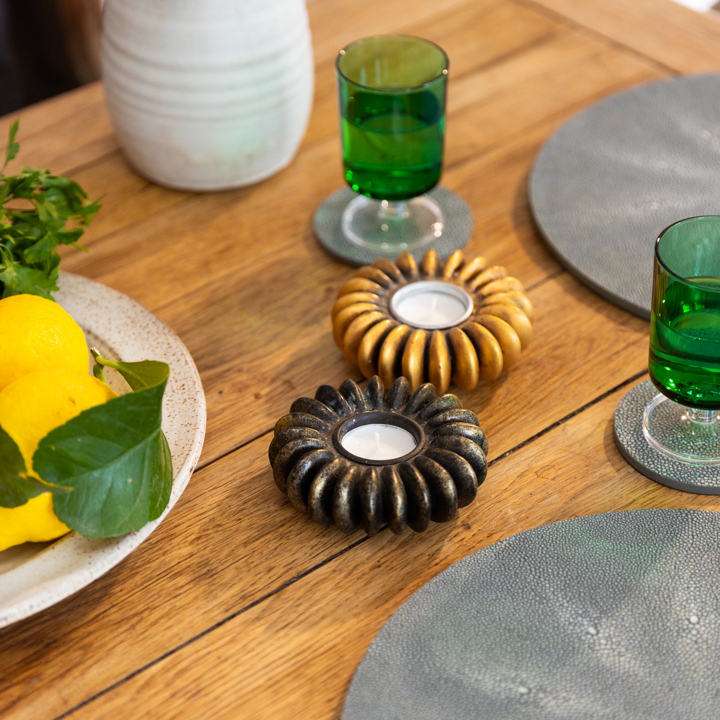 A bronze-colored tea light holder made to resemble a seed pod