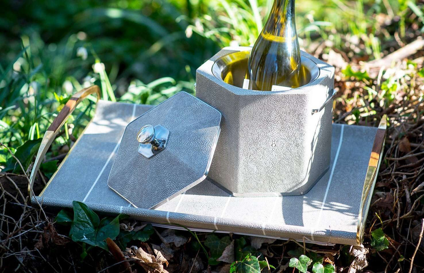 Ice Bucket in Barley Shagreen with a bottle inside, featuring a stainless steel exterior with polished accents and a faux shagreen exterior in Taupe.